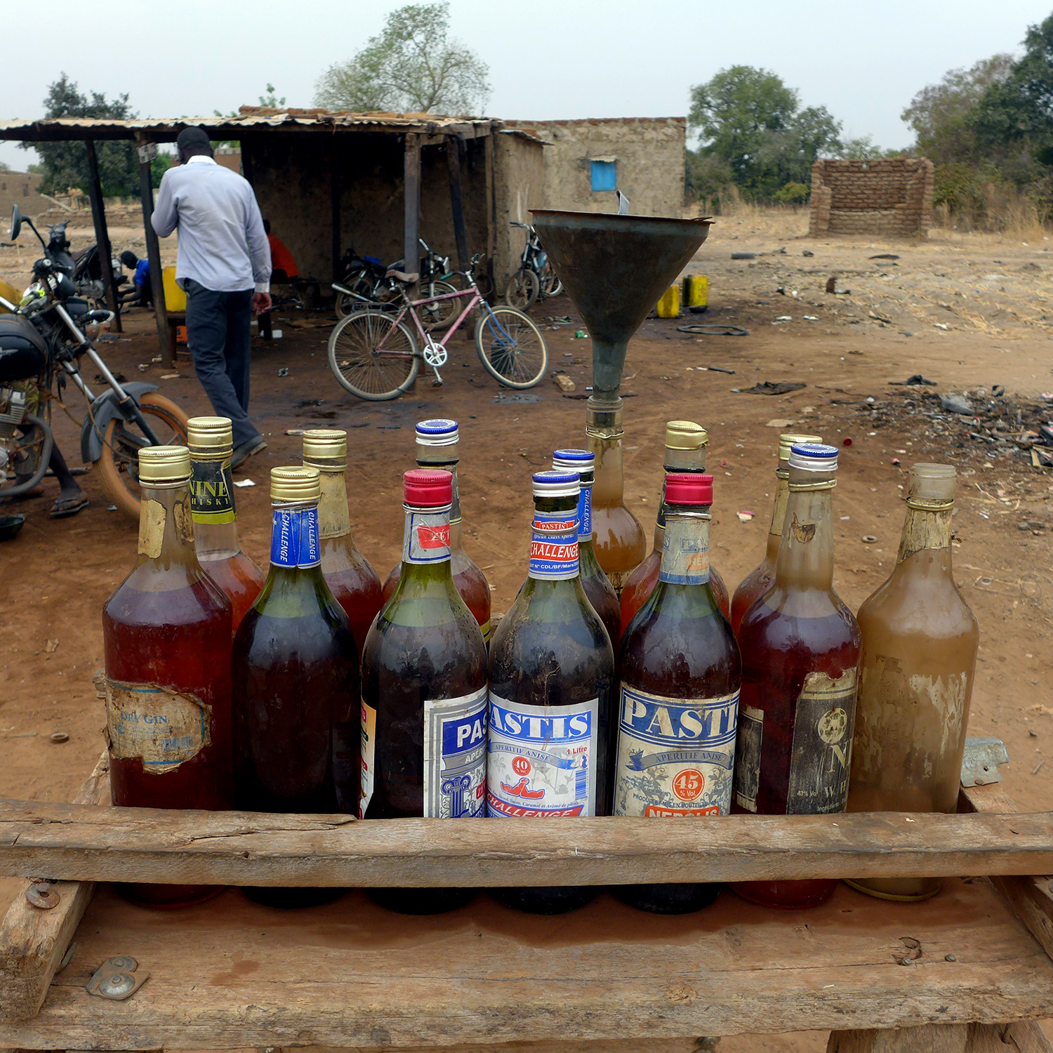 Attention ! Il ne s’agit pas de l’épicerie qui vendrait des bouteilles d’alcool. C’est du carburant qui est vendu au litre et réservé aux motos © Globe Reporters