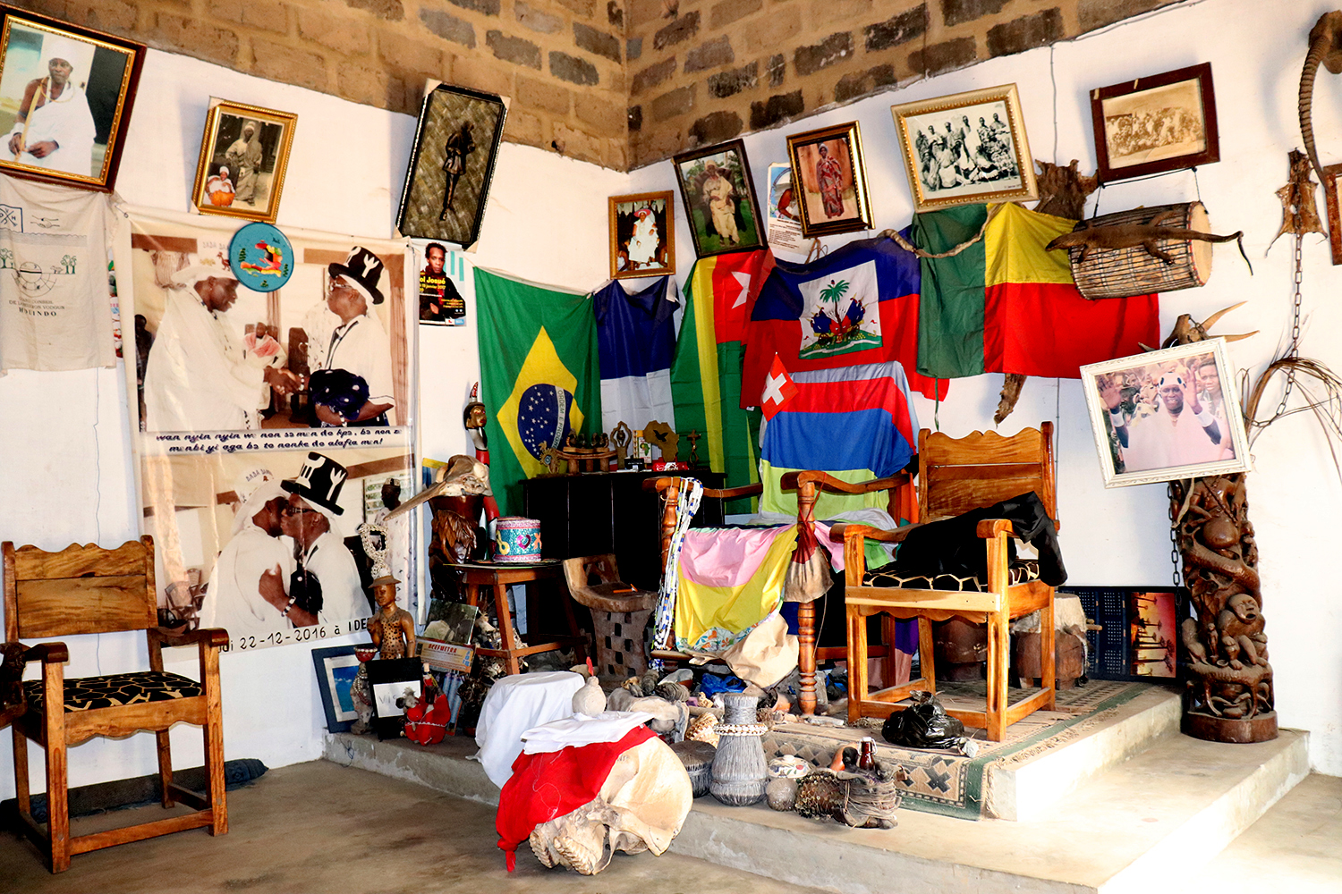 Salon de réception de Sa Majesté DAAGBO HOUNON HOUNA II avec des drapeaux des pays comme Brésil et des fétiches