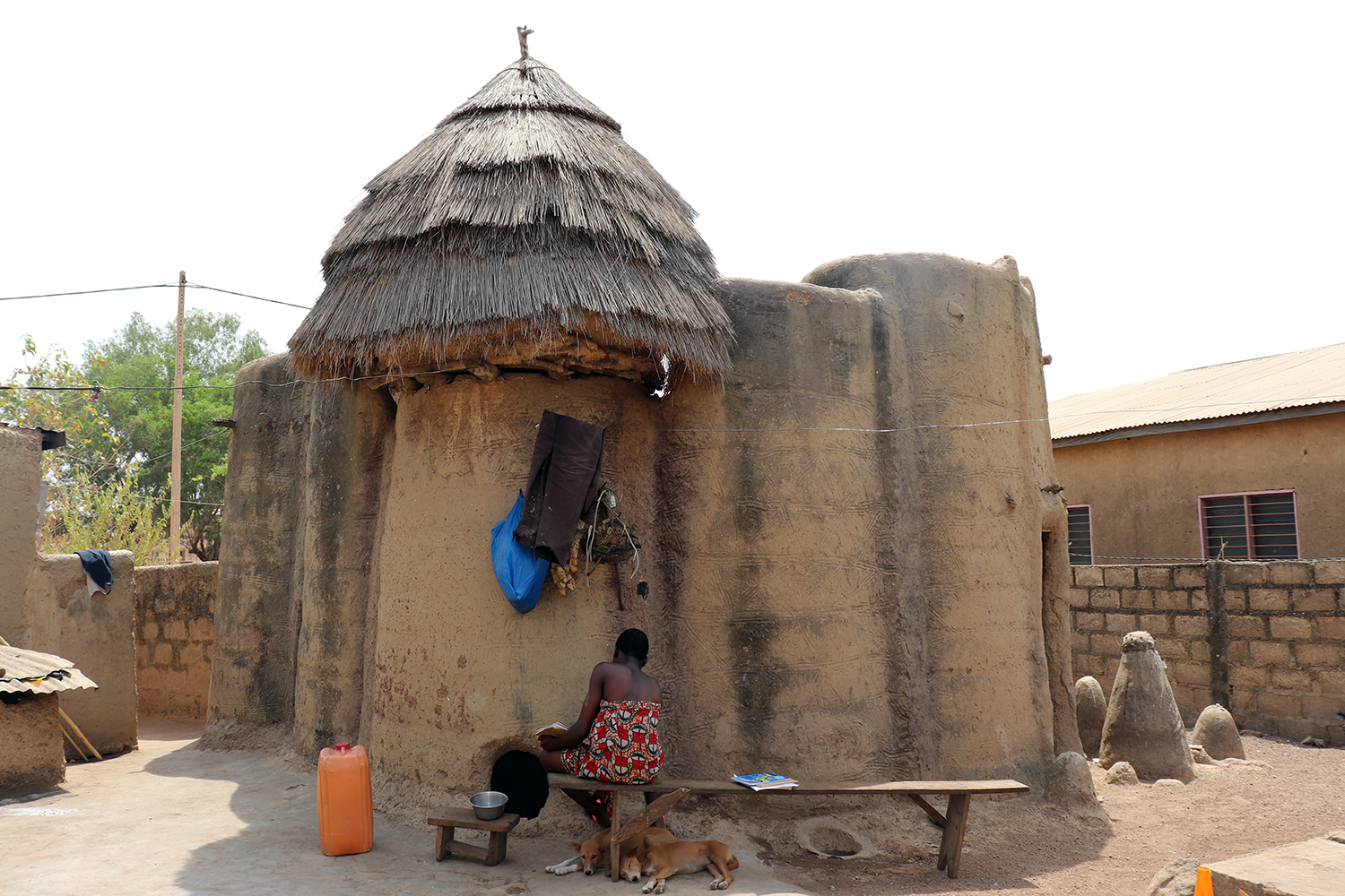 La forme des tata somba est celle d’une forteresse miniature. Une fois la porte d’accès close, il est difficile d’y pénétrer. À droite sur la photo, les fétiches qui protègent la maison et à la famille. 