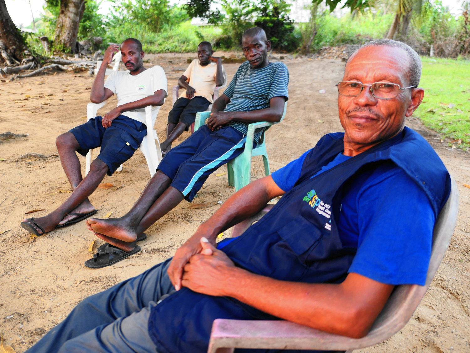 Sa majesté Njokou DJONGO, chef du village d’Ebodjé, en compagnie de ses notables réunis sous le manguier face au bâtiment de la chefferie traditionnelle © Globe Reporters