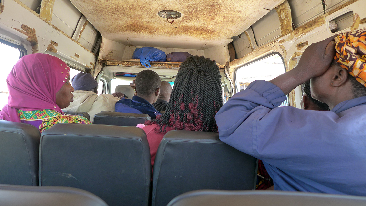 L’envoyée spéciale monte à l’arrière d’un taxi collectif qui dessert les petits villages de la route secondaire © Globe Reporters