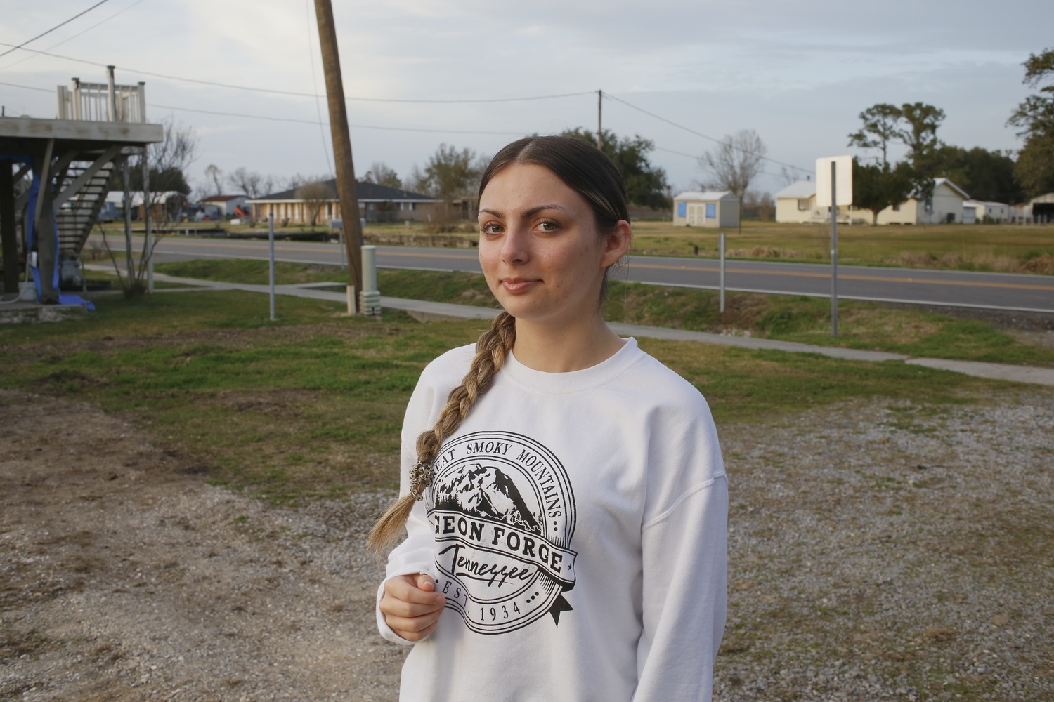 Portrait d’Isabella MATHERNE, devant le bayou Pointe-aux-Chênes et une maison détruite par l’ouragan Ida en 2021 © Globe Reporters 