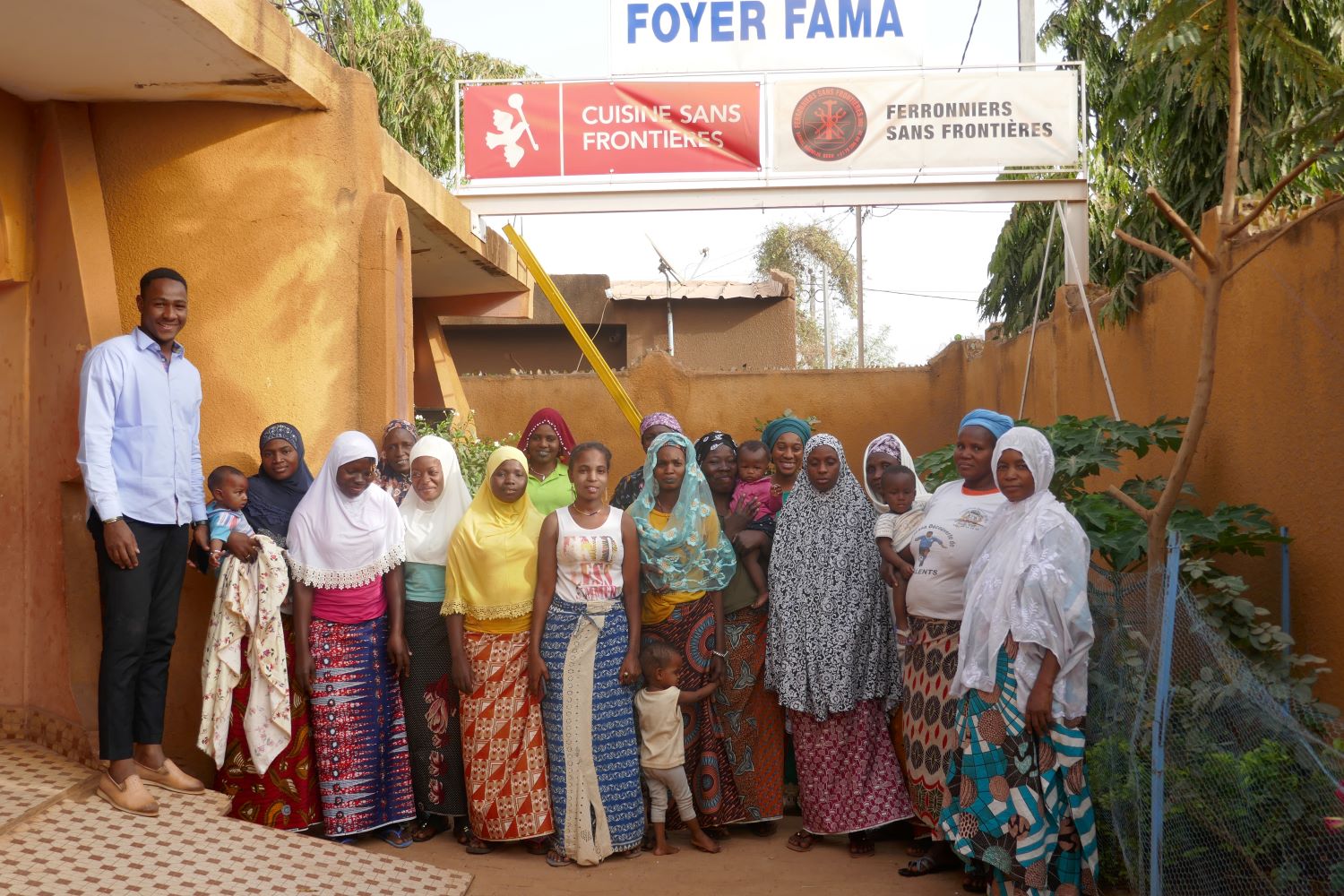 Dans la cour du Foyer FAMA, les femmes qui habitent et qui se forment pour être des petites commerçantes et pouvoir maintenir leurs enfants. Mohamed est le logisticien du foyer et aussi celui qui joue et sur les enfants © Globe Reporters