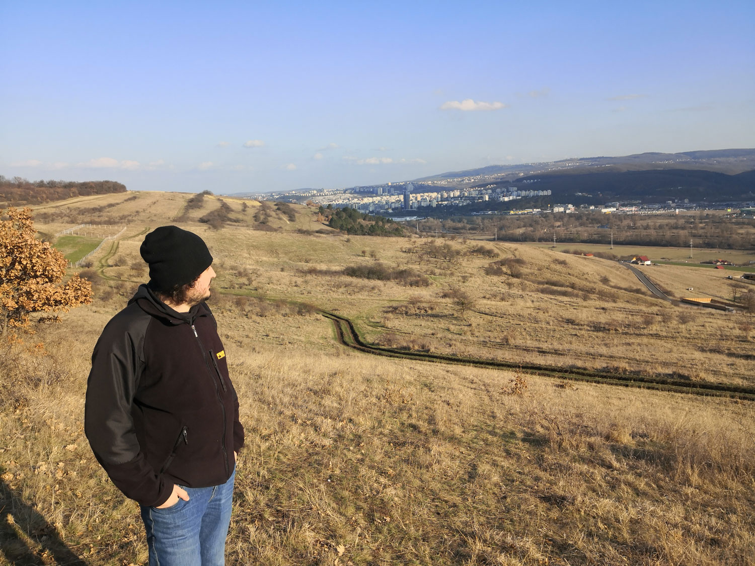 On fait quelques pas avec Alexandru en direction de la forêt après avoir laissé la voiture au bord de la route, l’urbanisation est aussi galopante sur les collines d’en face © Globe Reporters