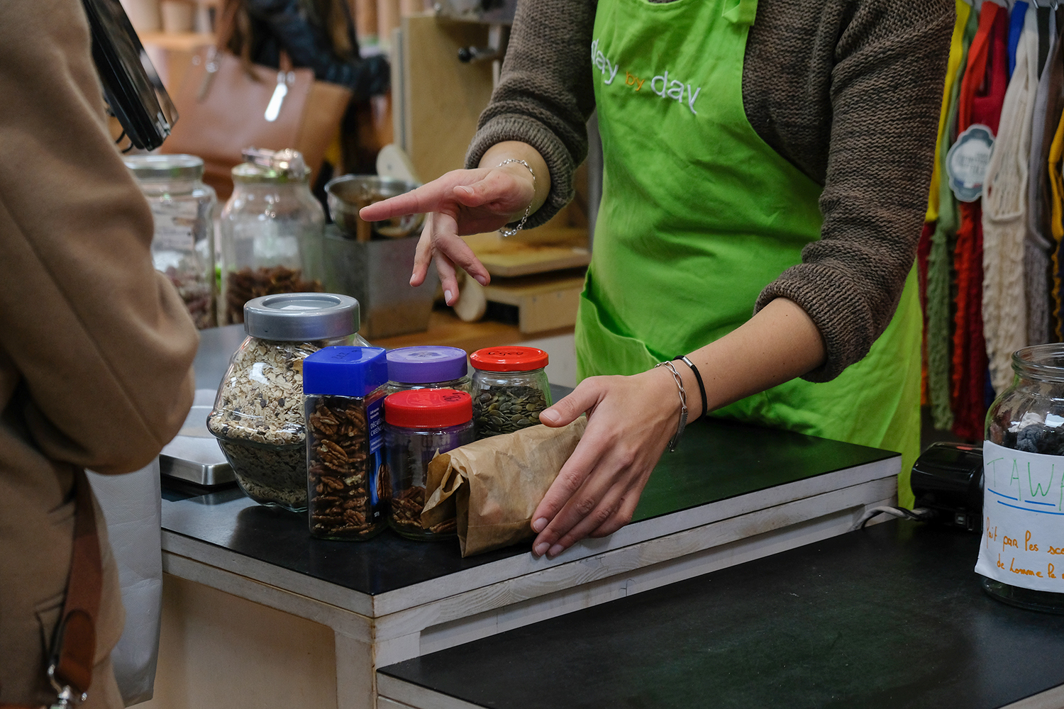 Dans une épicerie en vrac, les clients viennent avec leurs contenants pour faire leurs courses : les marchandises sont sans emballage et hors de questions de distribuer es sachets plastiques. 