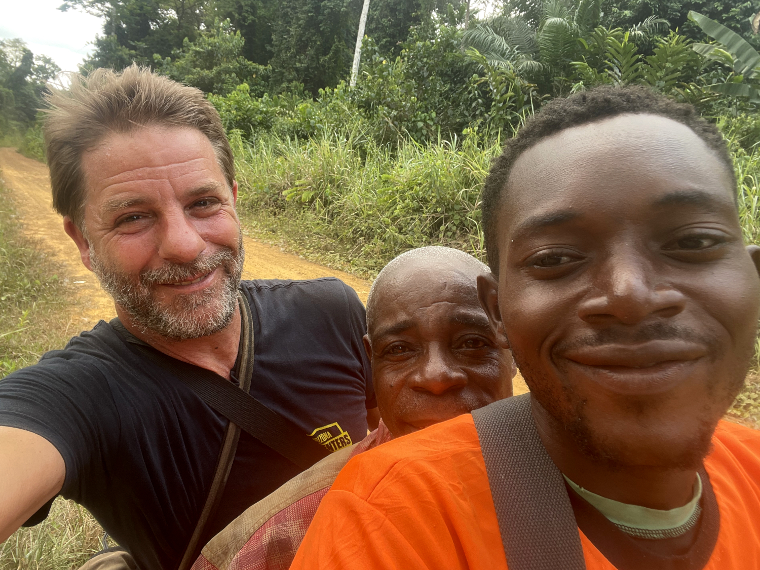 Sur la moto de Patrick avec Sa Majesté Henry, chef de la communauté des pygmées-bagyeli de la région de Campo, en route pour son domicile © Globe Reporters