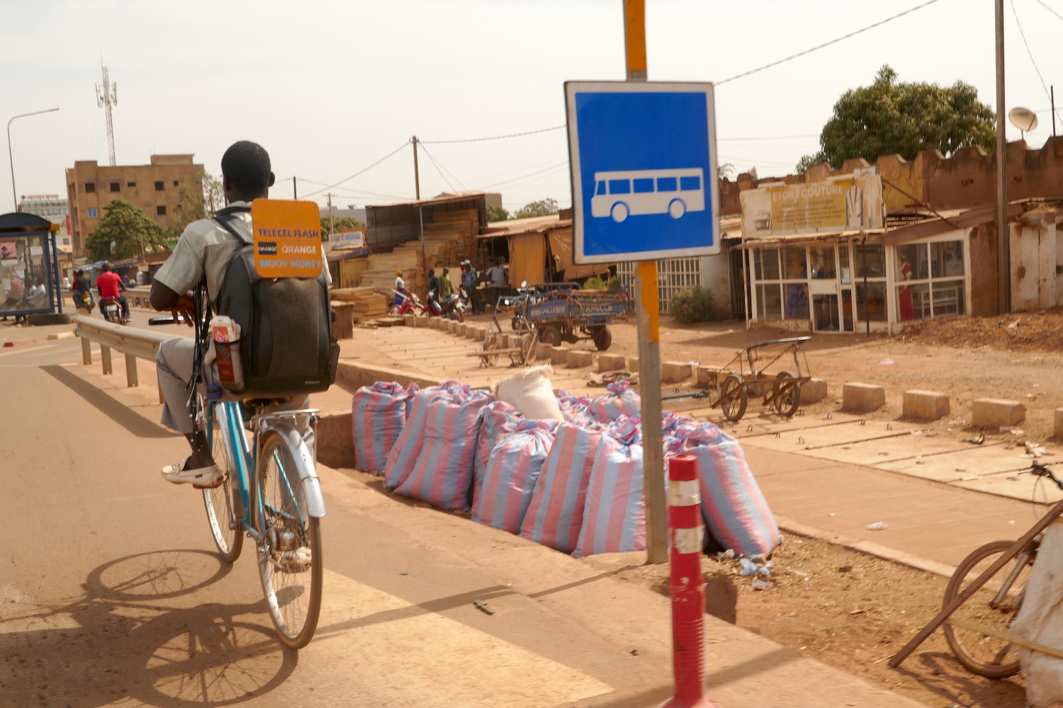 Sur la moto en chemin pour la rencontre avec AGN, Tatiana et Madi, l’équipe de Globe Reporters, croisent des gens comme ce jeune à vélo qui vend des unités pour charger des téléphones portables © Globe Reporters