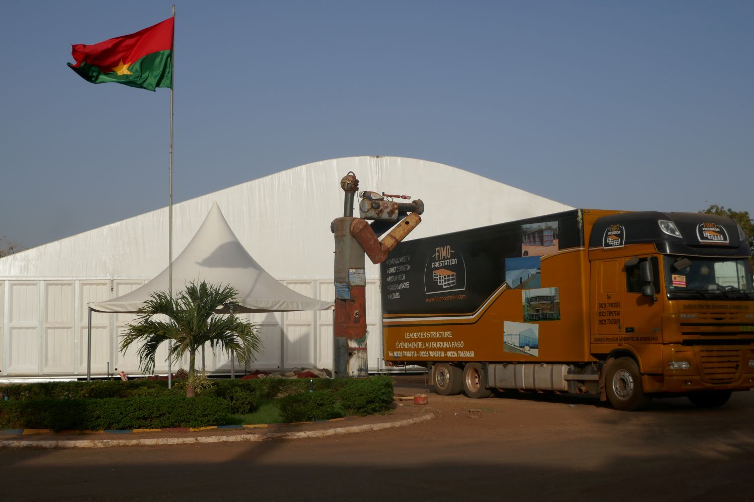 Au centre du parvis, une énorme sculpture rend hommage au cinéma et veille sur un camion qui témoigne des travaux pour la préparation de la 28ème édition du Festival © Globe Reporters