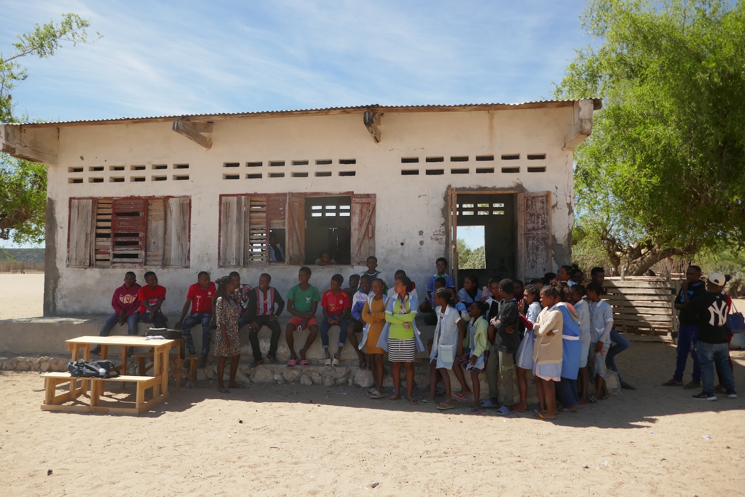 Élèves et professeurs du collège public d’Itampolo posent pour Globe Reporters devant un des bâtiments des classes et derrière la table où les entretiens ont lieu © Globe Reporters