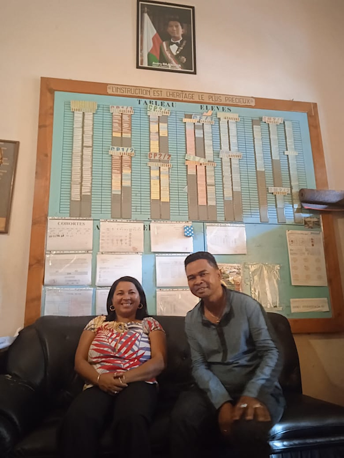 Njatovola ANDRIANALIVELO, chef de Division de la formation administrative et pédagogique et Nadia RAZAFINDRANAIVO, directrice de l’école primaire Analakely posent devant le tableau de bord dans le bureau de la directrice de l’école © Globe Reporters