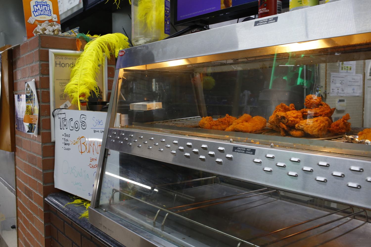 Kenny y prépare des plats louisianais, comme le poulet frit. Des plumes sont installées pour montrer son appartenance à une tribu © Globe Reporters