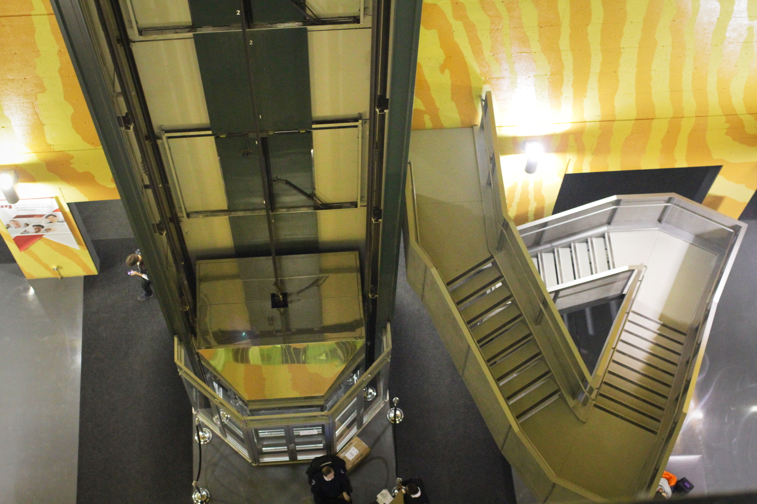 Point de vue sur le hall d’entrée et l’ascenseur en verre.