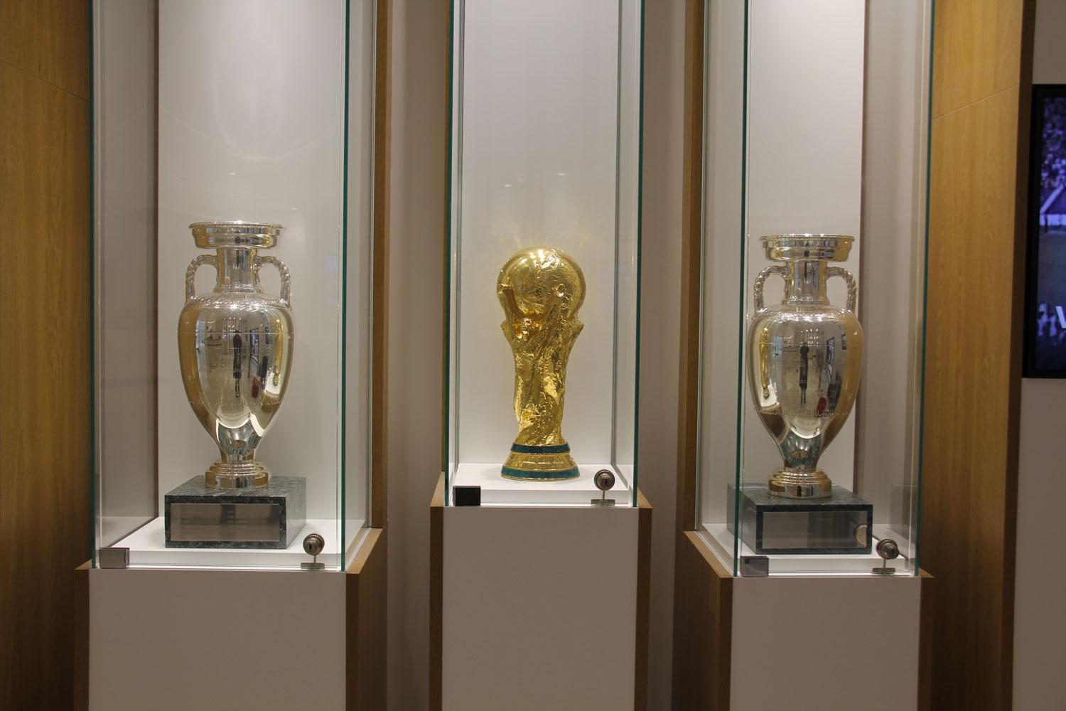 Dans des vitrines, de nombreux trophées gagnés par les différentes équipes de France. Et notamment la Coupe du monde 2018 entourée de deux coupes d’Europe © Globe Reporters