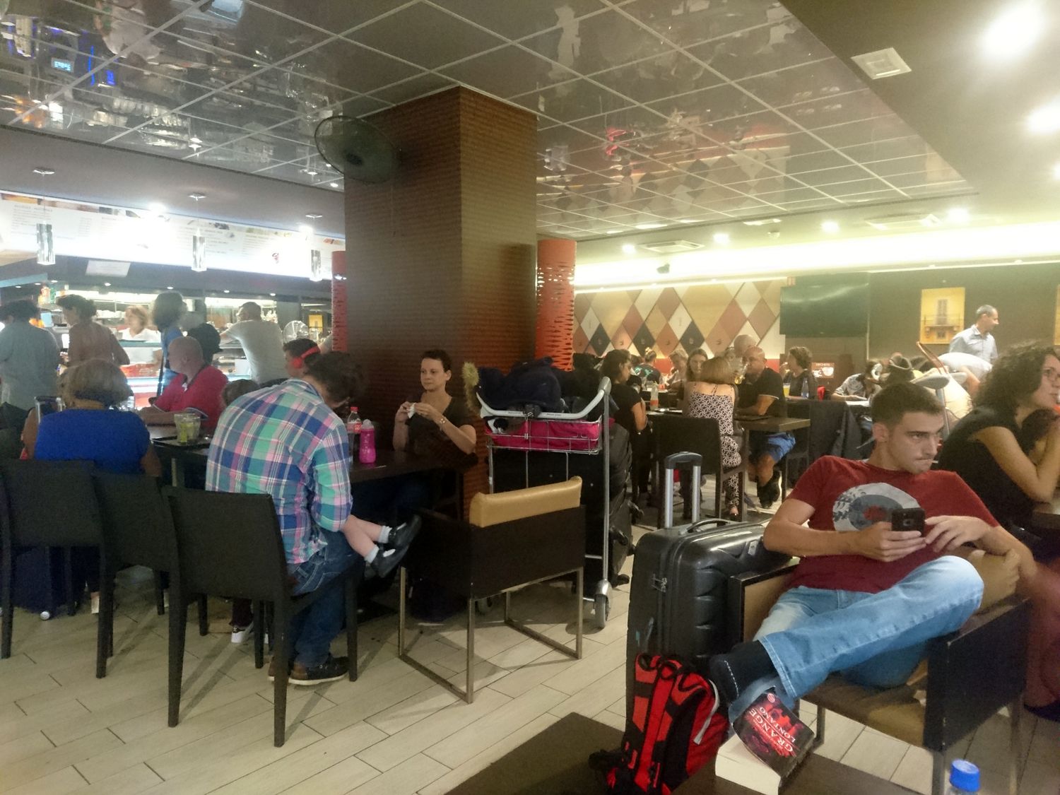 Le seul café où l’on peut s’asseoir dans l’aéroport est très prisé car les voyageurs sont arrivés souvent bien en avance.