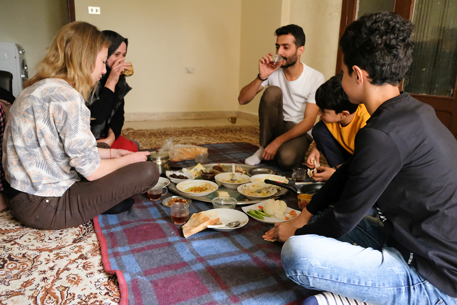 Les différents mezze sont apportés sur un grand plateau et posé à même le sol. Nous nous asseyons directement par terre. « Nous sommes plus à notre aise comme ça », précise Moustafa. Au menu : œufs sur le plat, hoummous, baba ghanoush, olives, fromages, confitures que nous mangeons avec du pain © Globe Reporters