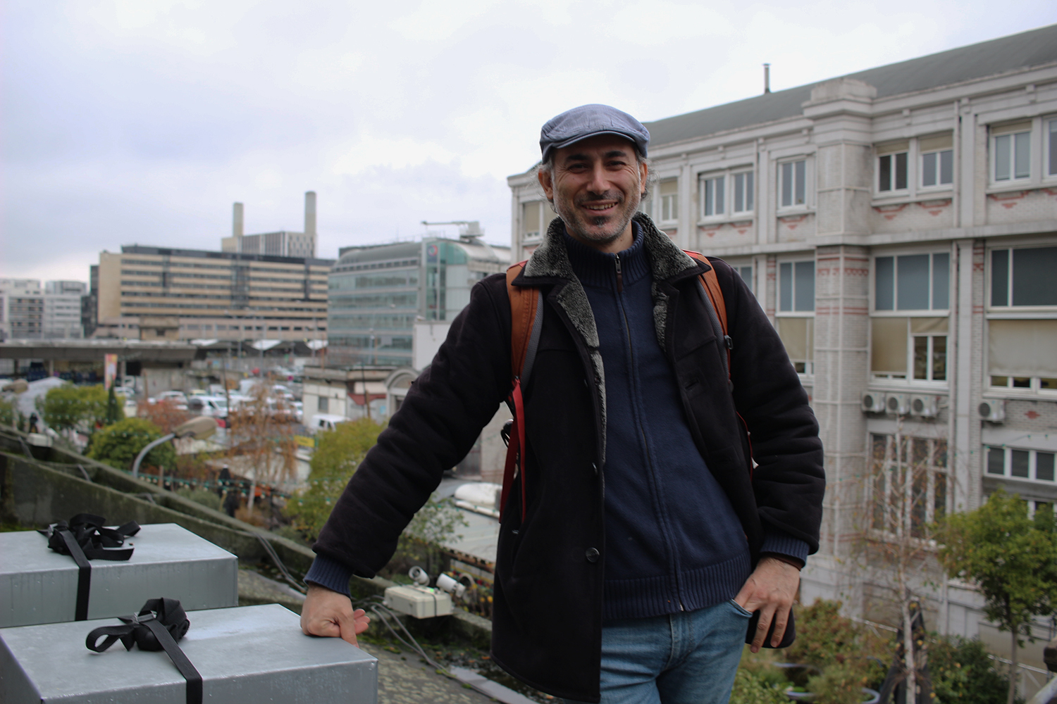 Volkan pose près de ces ruches. Derrière lui, les bâtiments du 12ème. Nous sommes très proches de la Gare de Lyon dont nous pouvons apercevoir voies ferrées © Globe Reporters 