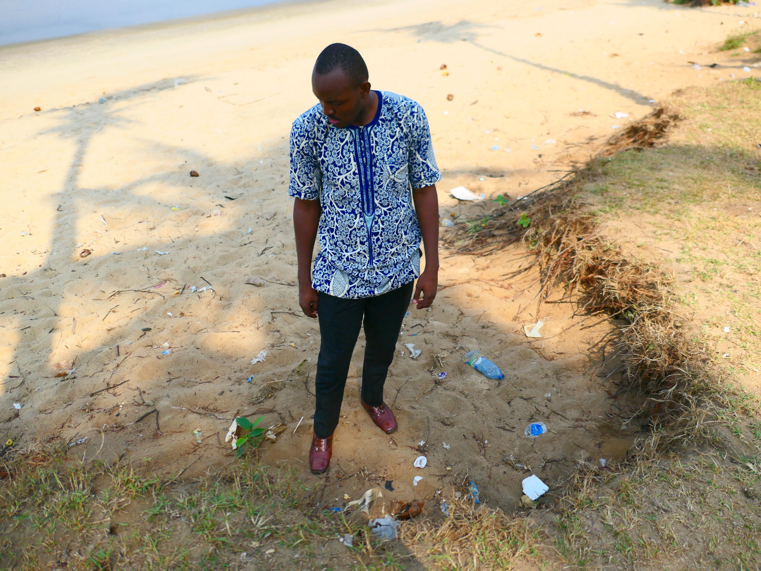 Ulrich BILOUNGA se place là où la micro-falaise qui borde la plage est le plus rognée par la mer © Globe Reporters