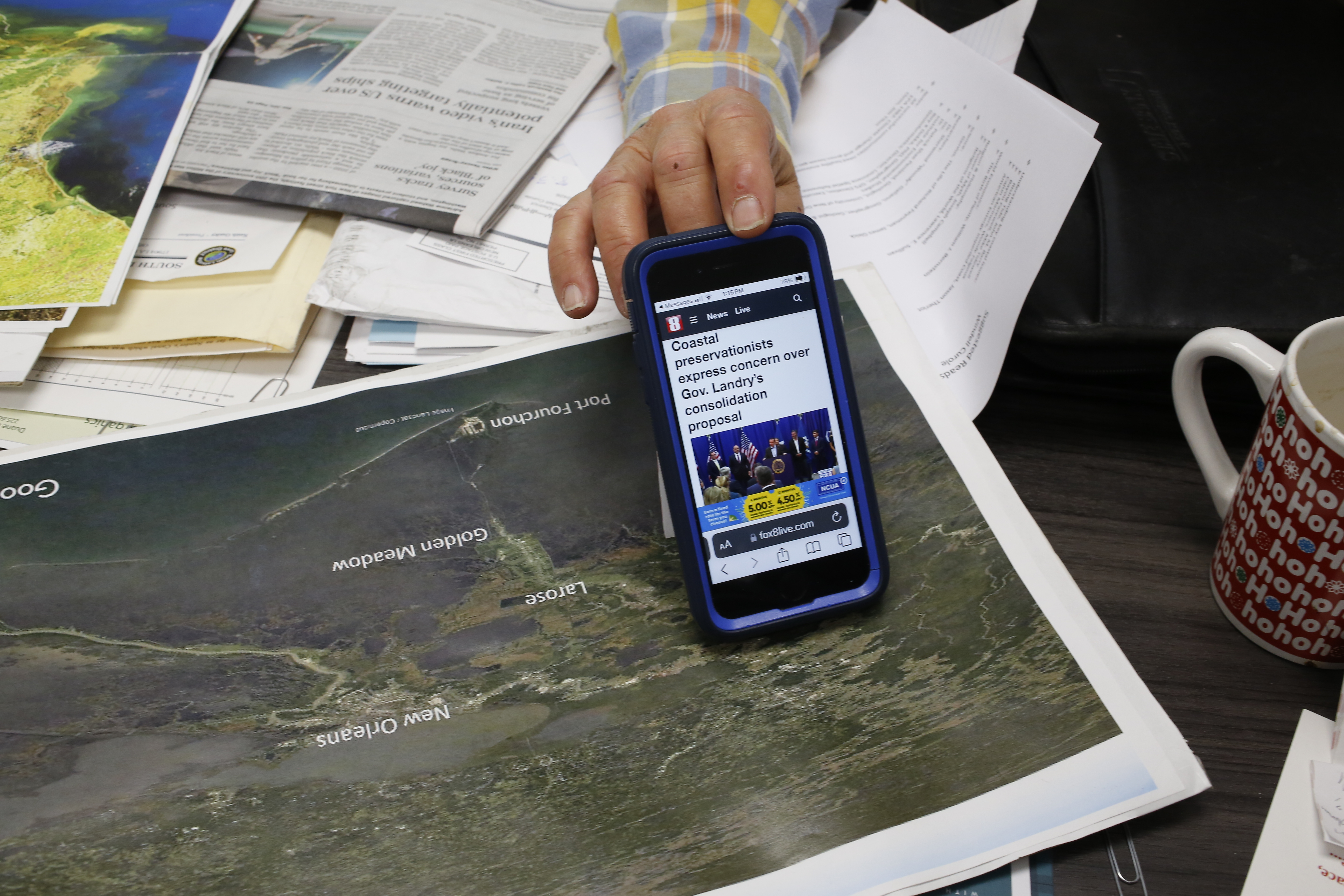 Windell montre un article qu’il est en train de lire : des personnes qui oeuvrent à la protection de côtes s’inquiètent de la politique du nouveau gouverneur de Louisiane © Globe Reporters 