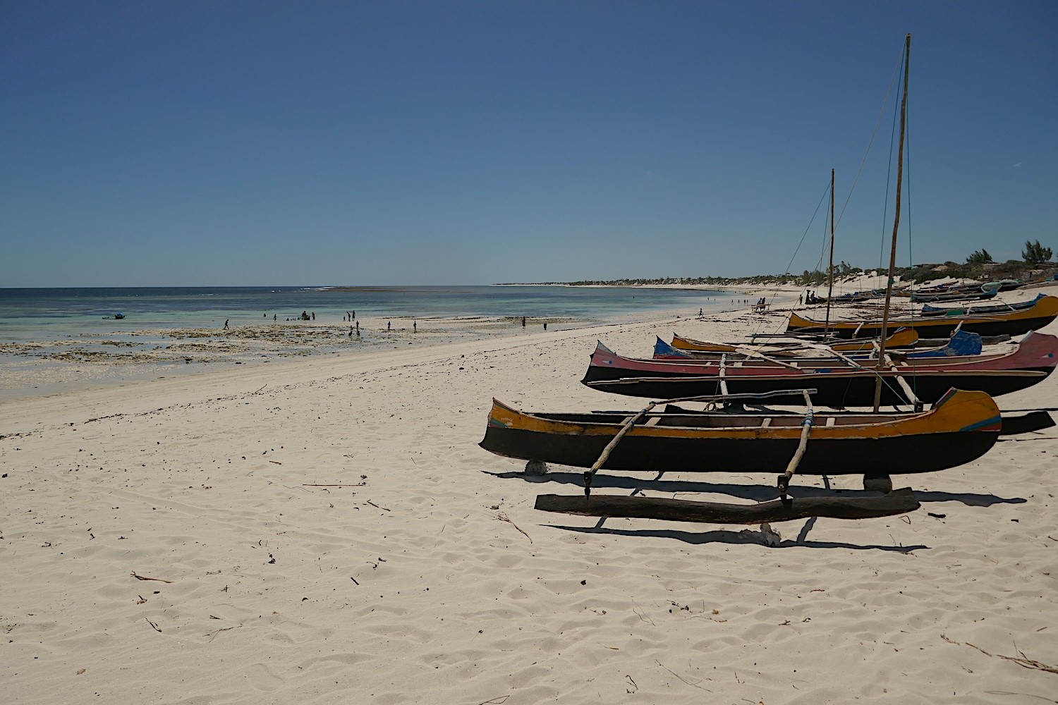 Tatiana et Florence cheminent par la plage de sable blanc. Les pirogues indiquent qu’un village est proche © Globe Reporters 