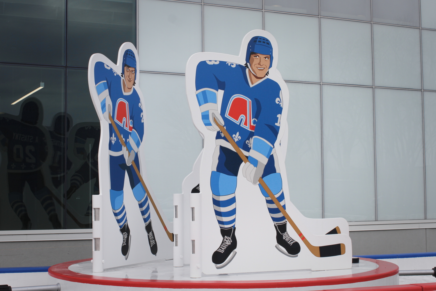 Des panneaux sous forme de joueurs de hockey devant le Pavillon de la Jeunesse.