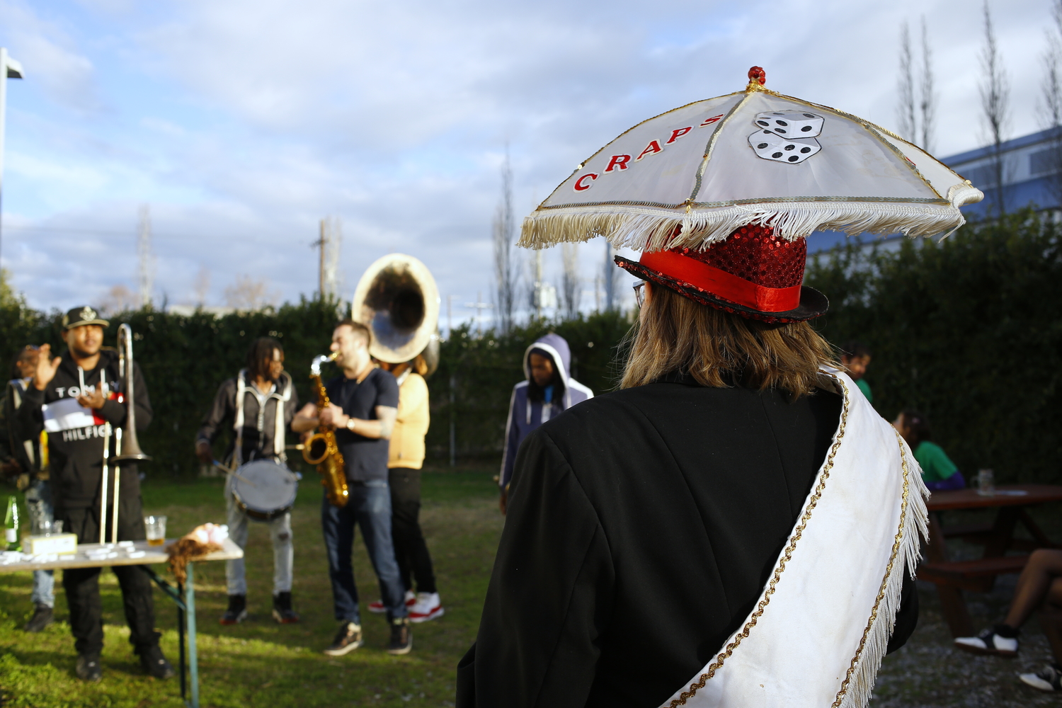 Concert de TBC pour un krewe de Mardi gras. L’ombrelle, à la base pour se protéger du soleil, est un objet très commun dans les parades et elle guide souvent la marche © Globe Reporters