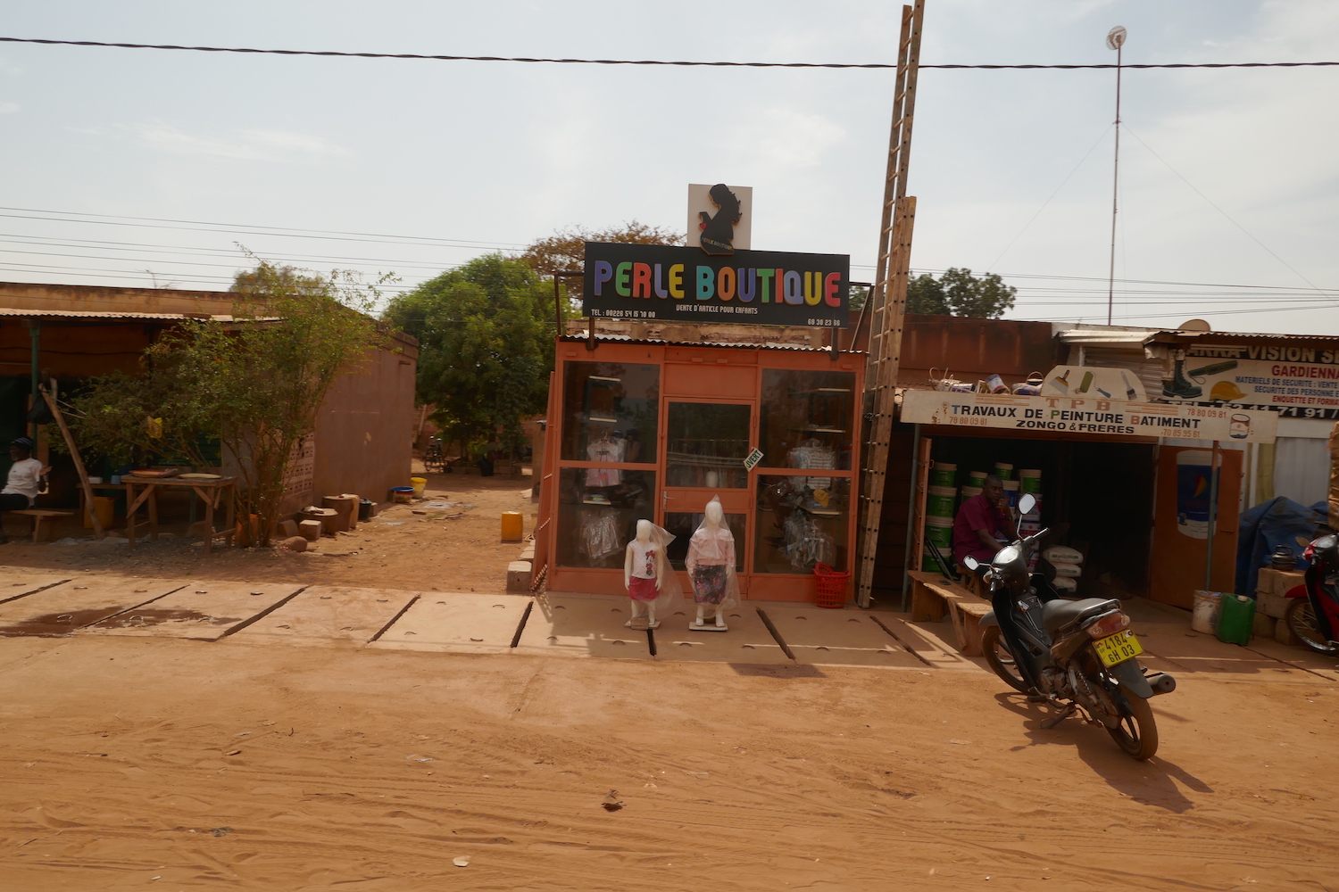 Vue depuis la moto d’une petite boutique typique des commerces de la capitale © Globe Reporters