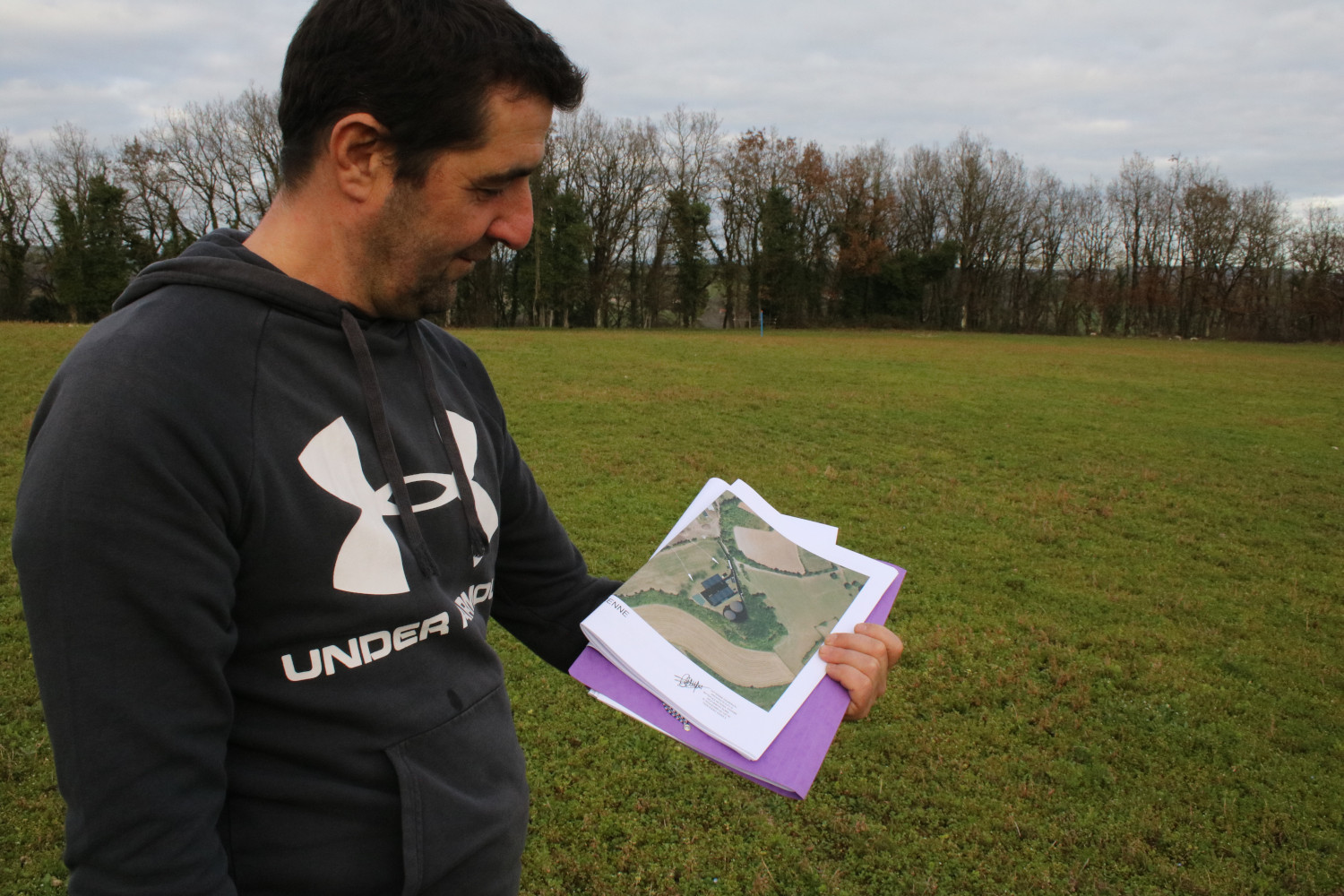 L’agriculteur nous emmène dans le champ où il veut faire construire ce méthaniseur. Il montre les plans du projet © Anouk PASSELAC / Globe Reporters