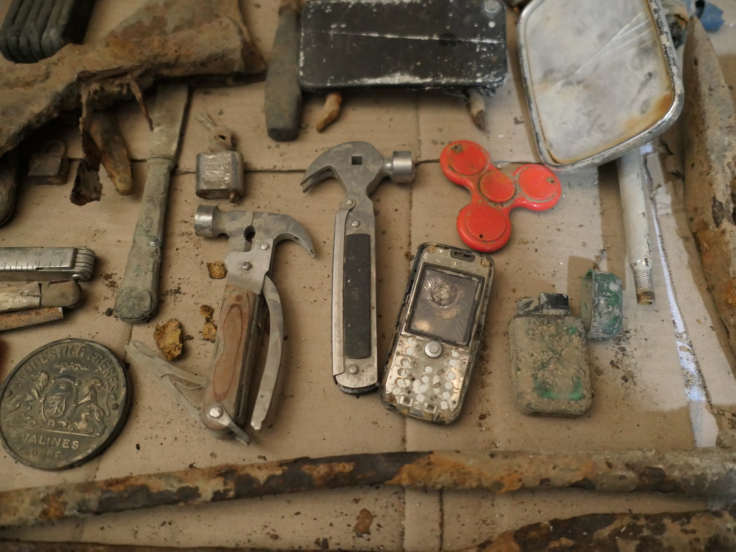 Avec son père et parfois des amis, Raphaël retrouve beaucoup d’outils de chantier et de petits objets. Ici, un téléphone, un briquet et des marteaux arrache-clous, etc. © Globe Reporters