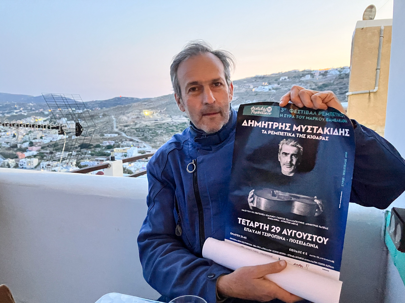 Antonis avec, à la main, une affiche du festival de 2018 © Globe Reporters 