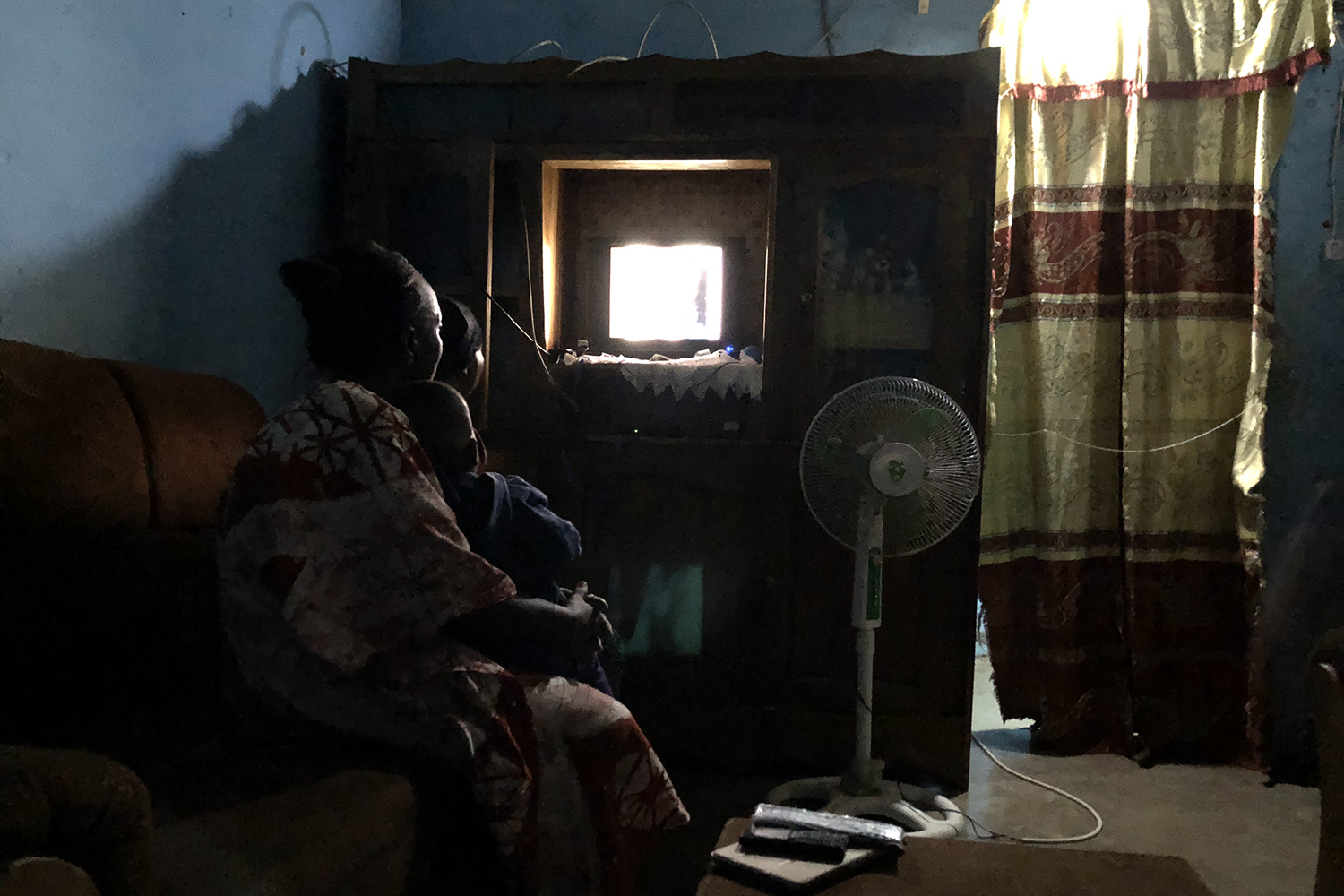 Simone regarde une télénovella dans le salon de la maison familiale.