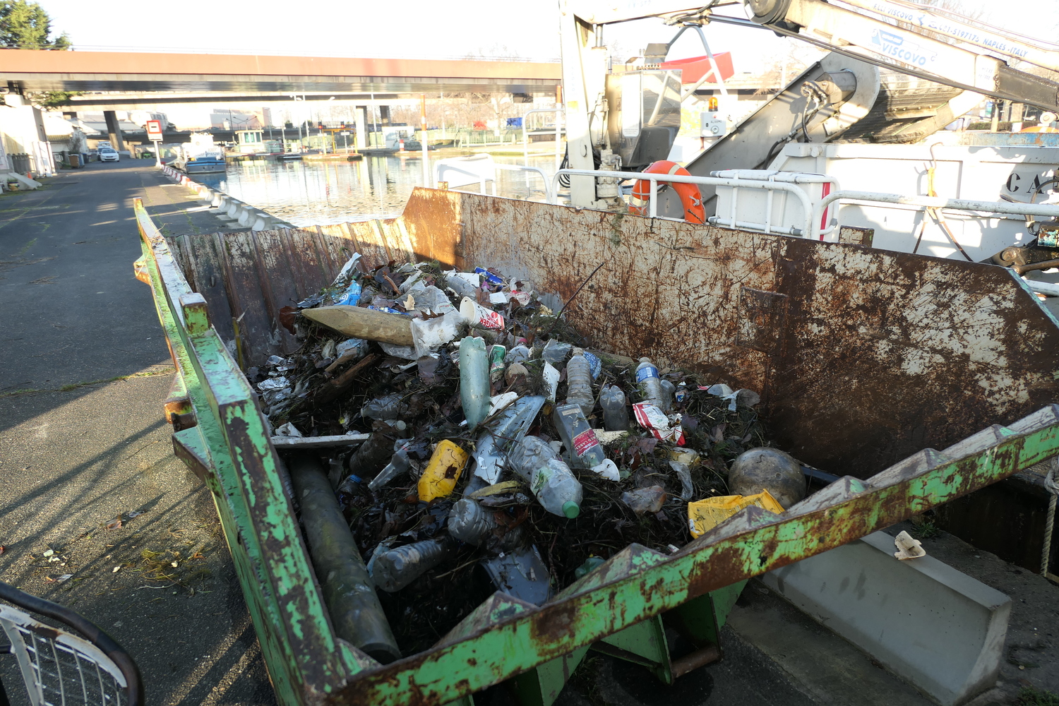 À la fin de leur tournée, les bateaux transfèrent leur collecte dans une autre benne, plus grosse, sur le quai. Les détritus seront amenés à la déchetterie plus tard © Globe Reporters