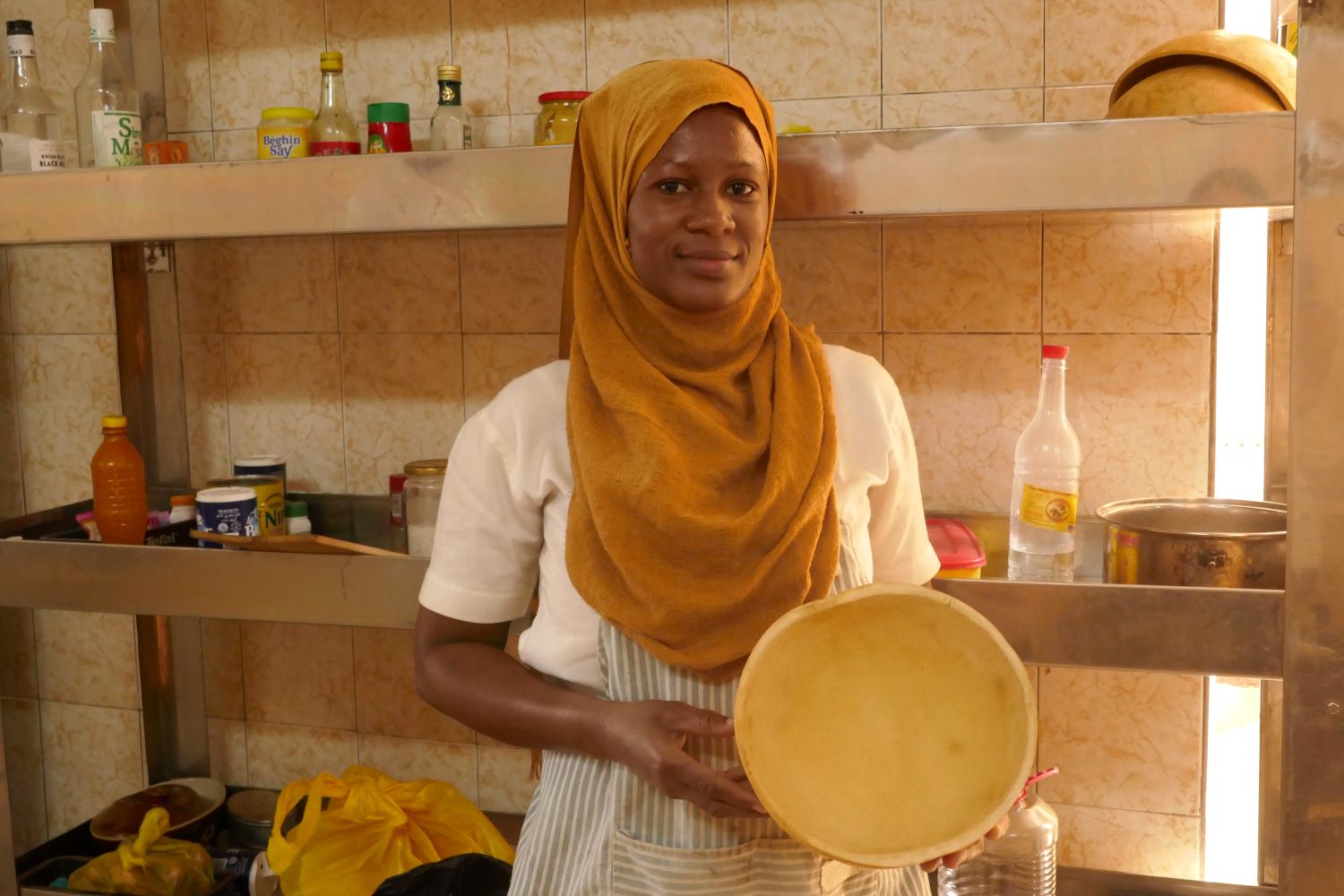 Habbibah GUIRA montre une calebasse, outil qui est présent dans toutes les cuisines burkinabés et qui sert de bol © Globe Reporters