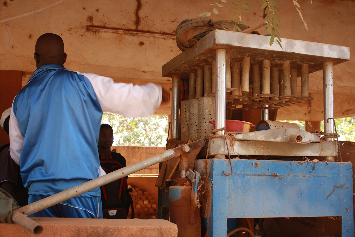 Le guide explique aux visiteurs le fonctionnement de la machine pour presser et obtenir des buchettes combustibles. 