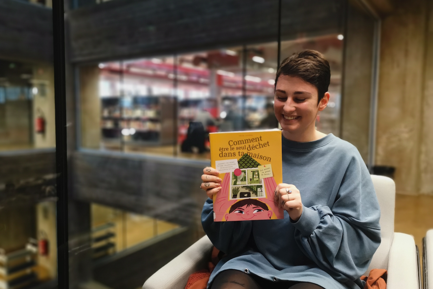 Celia pose avec son livre « Comment être le seul déchet dans ta maison » © Globe Reporters