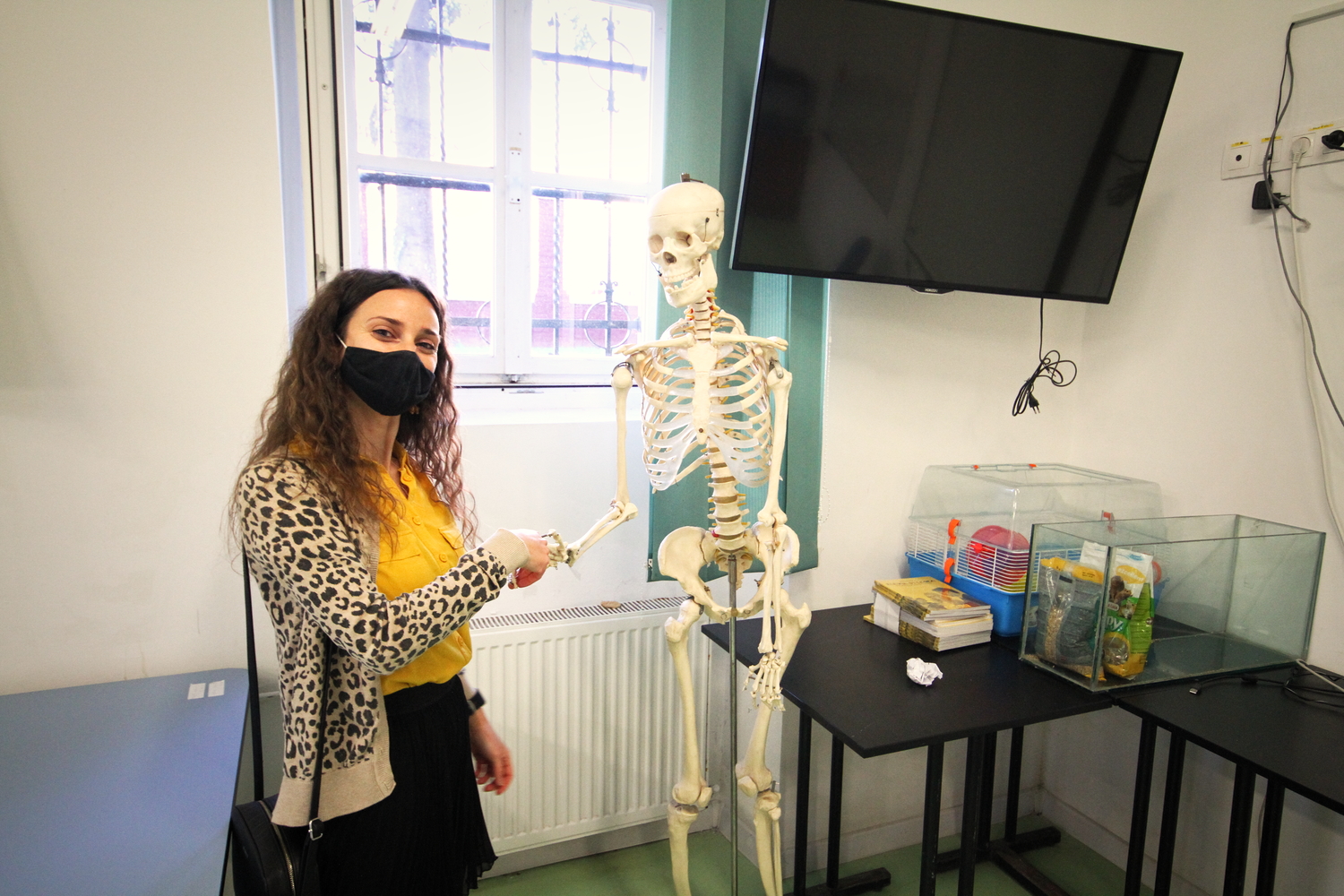 Roxana PUTAN, professeure de géographie, fait la visite du lycée. Elle présente la mascotte du cours de biologie © Globe Reporters