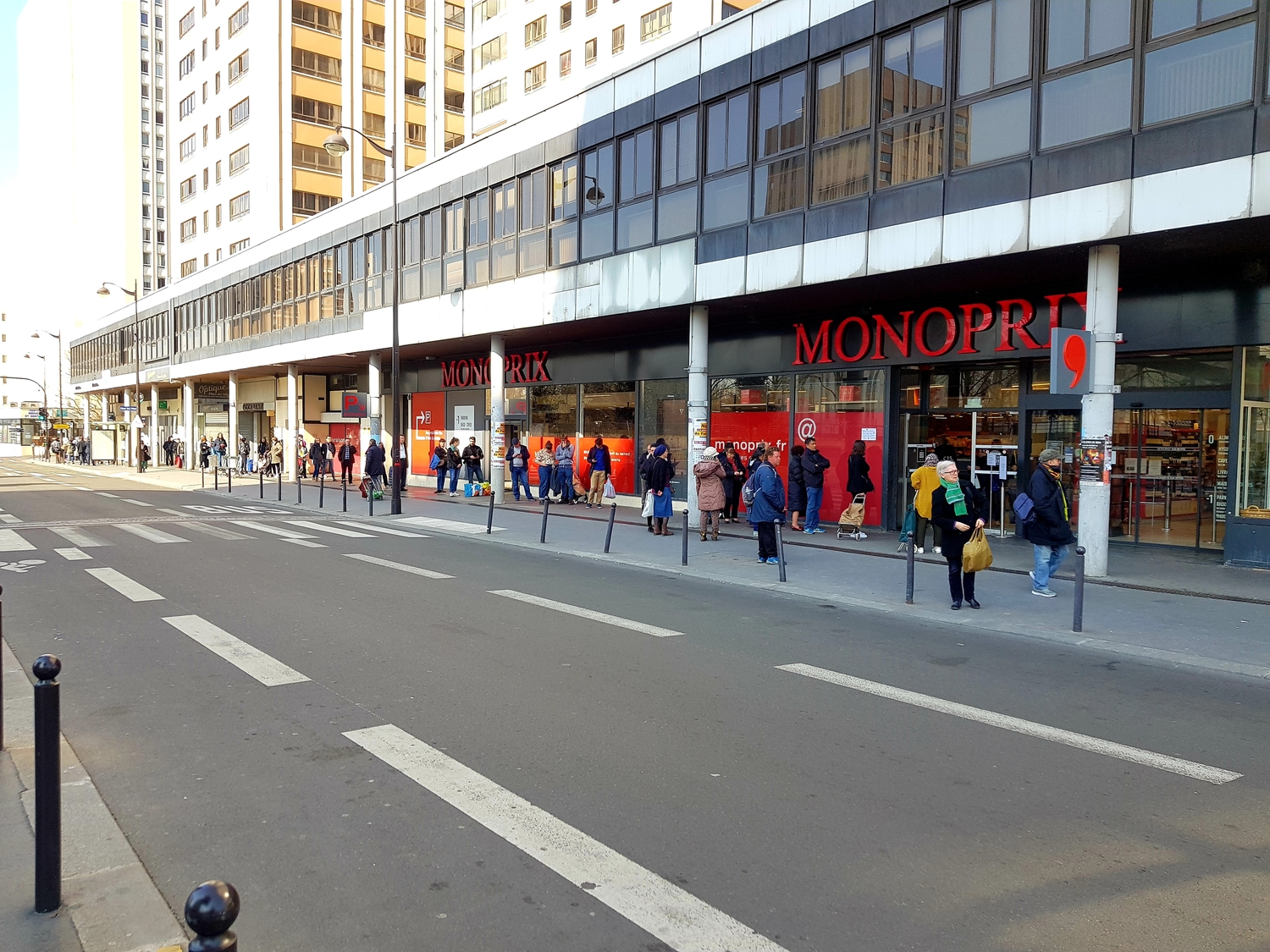 Les clients font la queue devant Monoprix, en respectant la distance de sécurité d’un mètre.