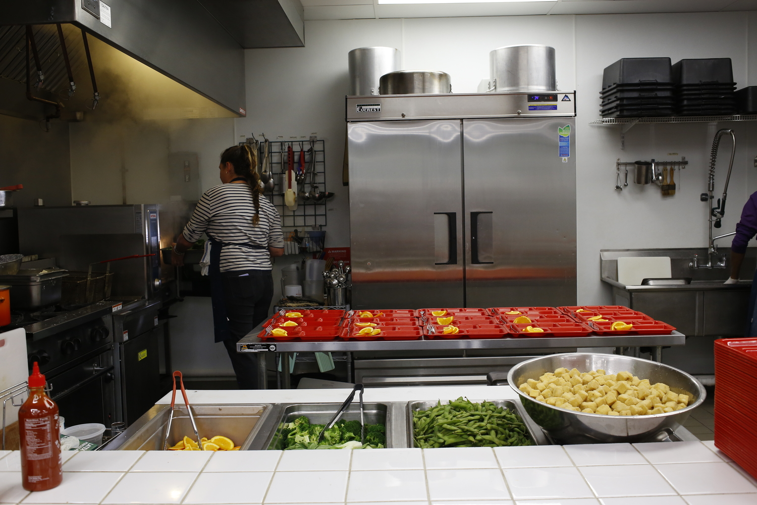 Chef Adrienne s’affaire dans la cuisine de la cantine © Globe Reporters