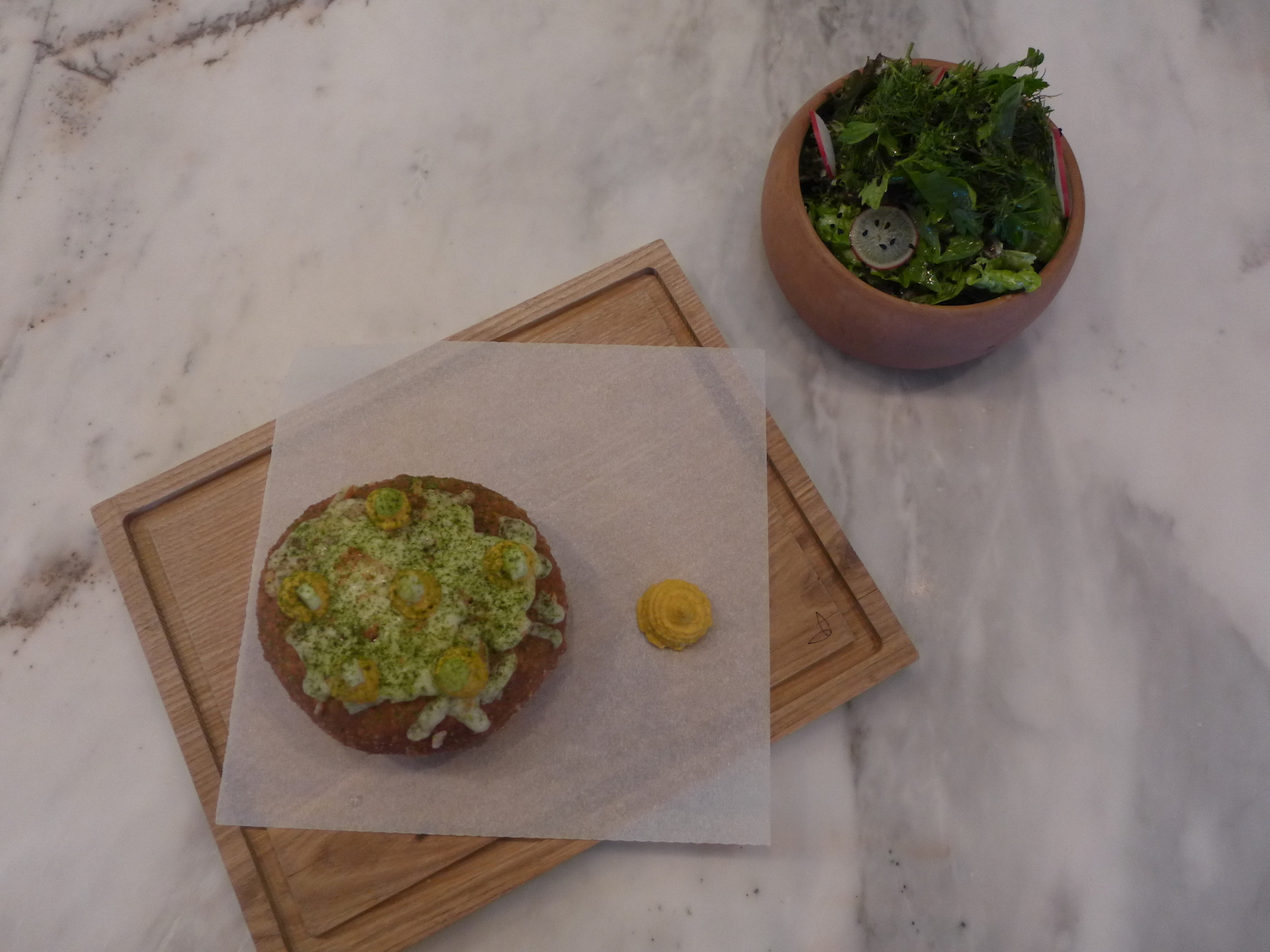 Une scoverga, beignet traditionnel revisité par Alex Petricean : le beignet est fourré de chifte, des boulettes de viande à l’ail. Il est recouvert de fromage grillé et d’une moutarde faite maison. La moutarde roumaine est un peu sucrée.