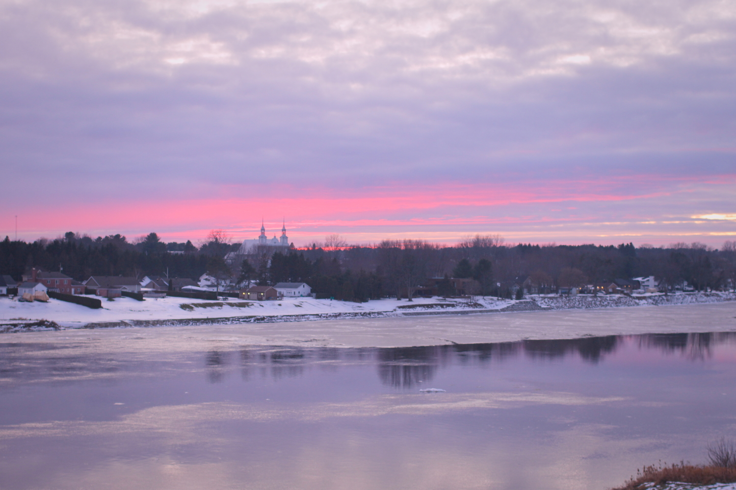 Coucher de soleil sur la rivière et le village d’en face.