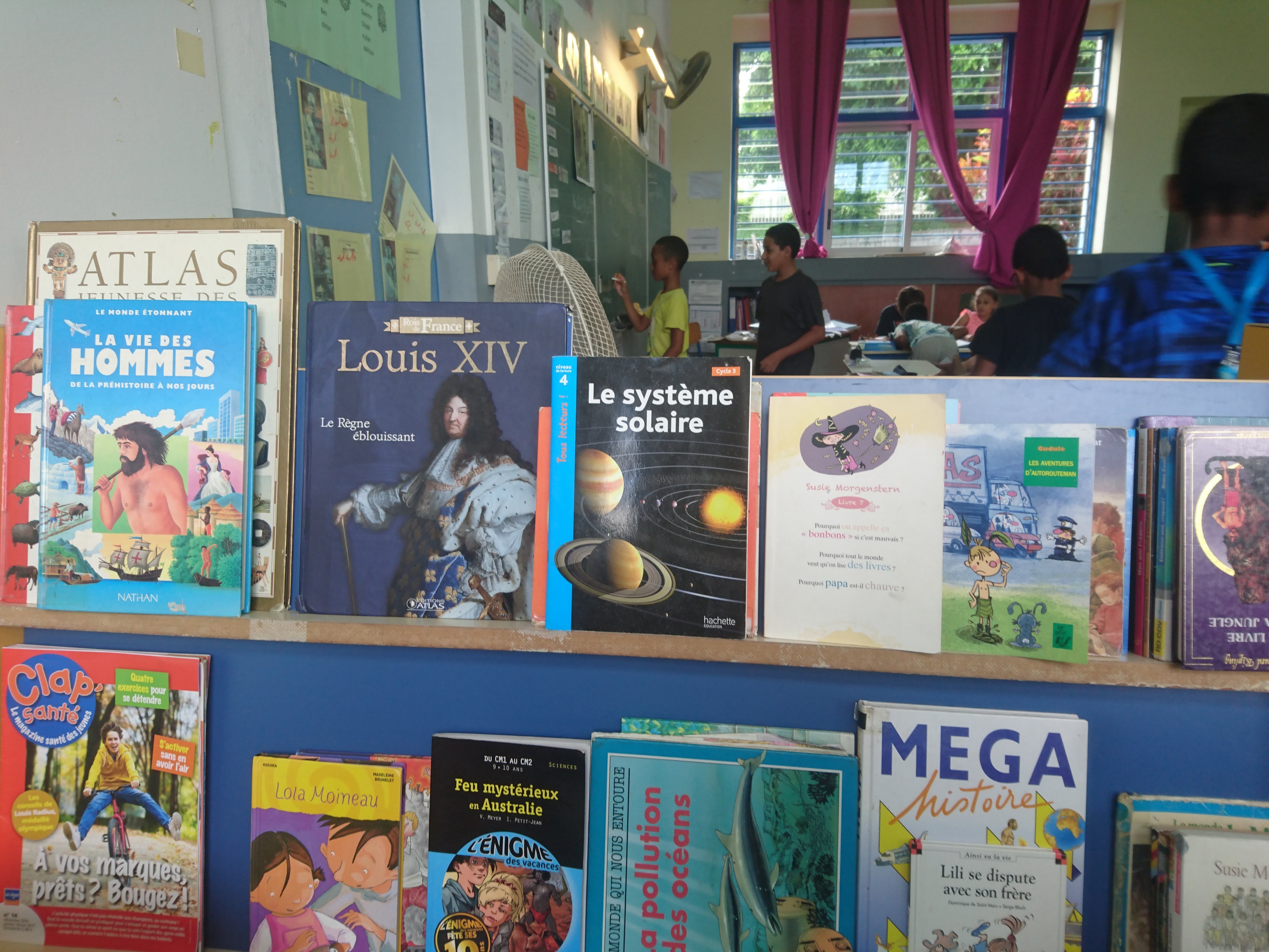 Dans la salle de classe, il y a un petit espace bibliothèque.