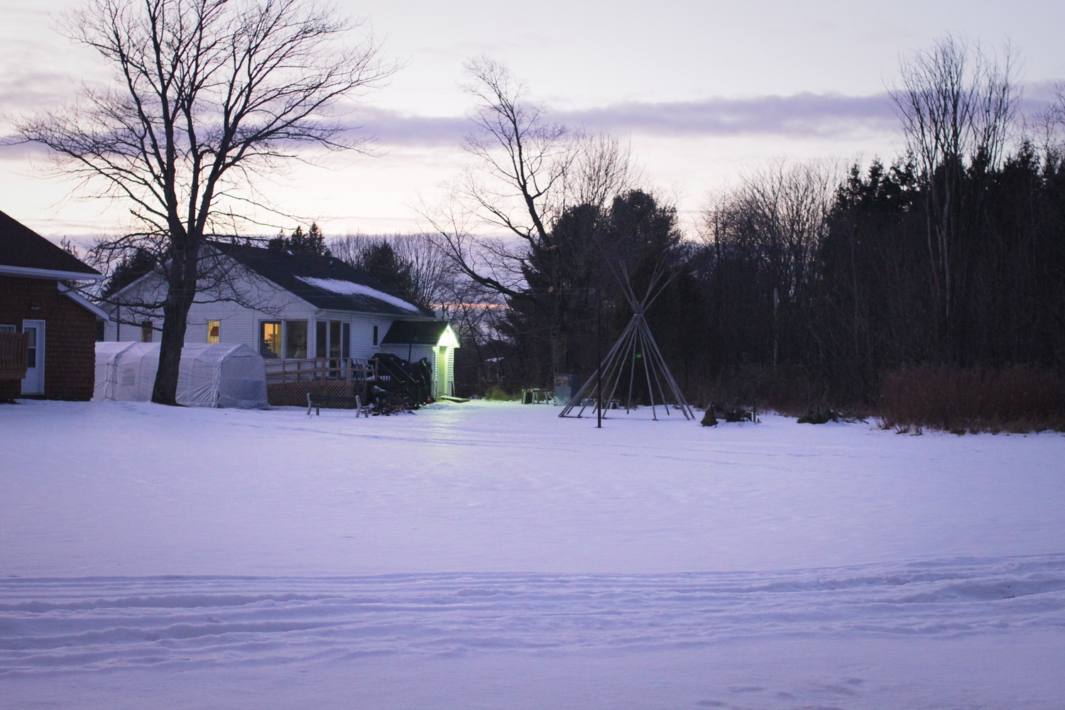 Une maison d’Odanak avec la structure d’un tipi dans le jardin.