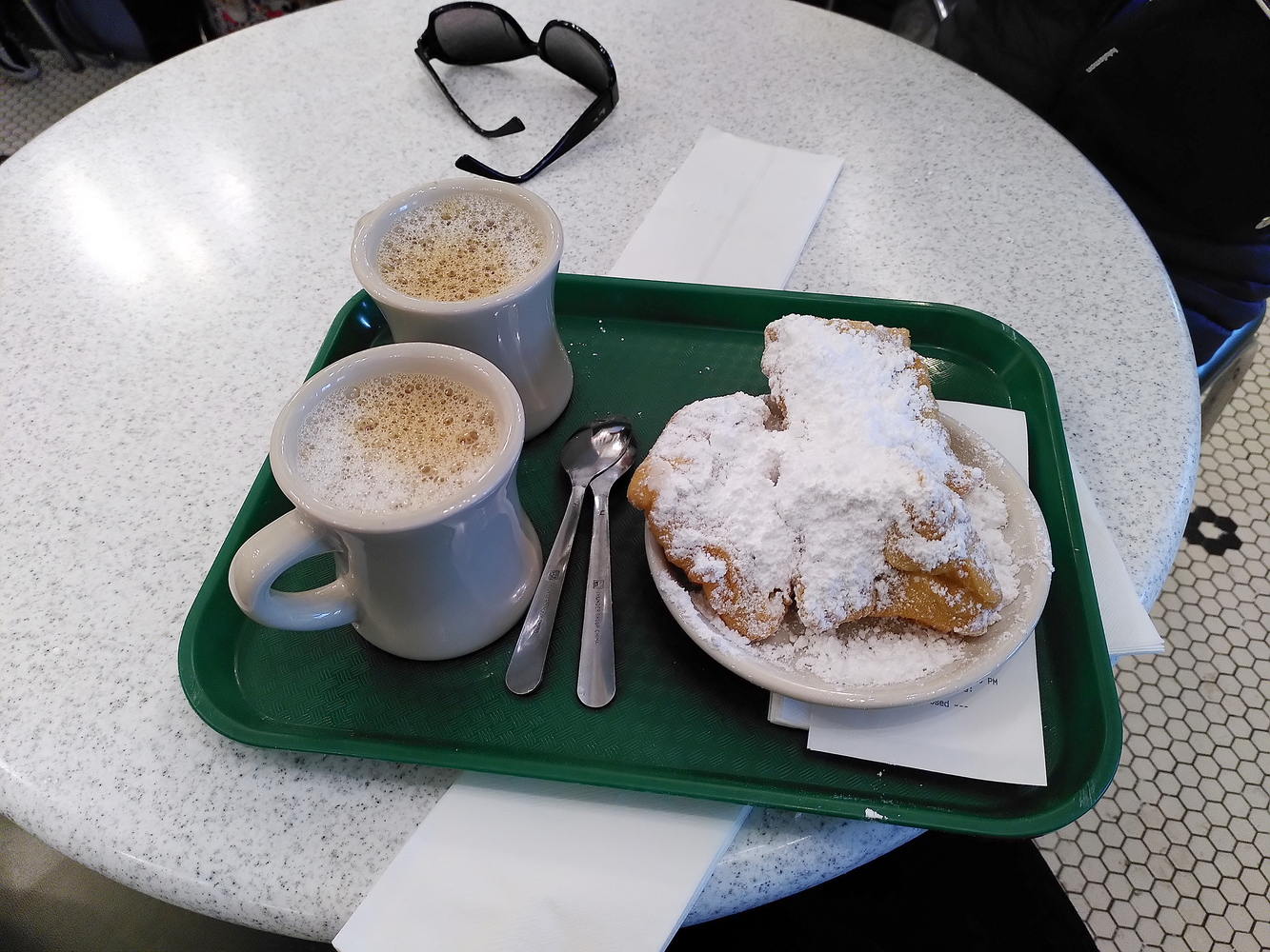 Notre envoyée spéciale déguste les beignets avec notre célèbre café au lait, une autre spécialité de la ville. Elle n’a pas réussi à les finir © Globe Reporters