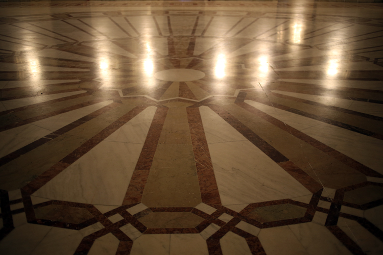 Décorations au sol qui reprennent les motifs d’un lustre suspendu au-dessus