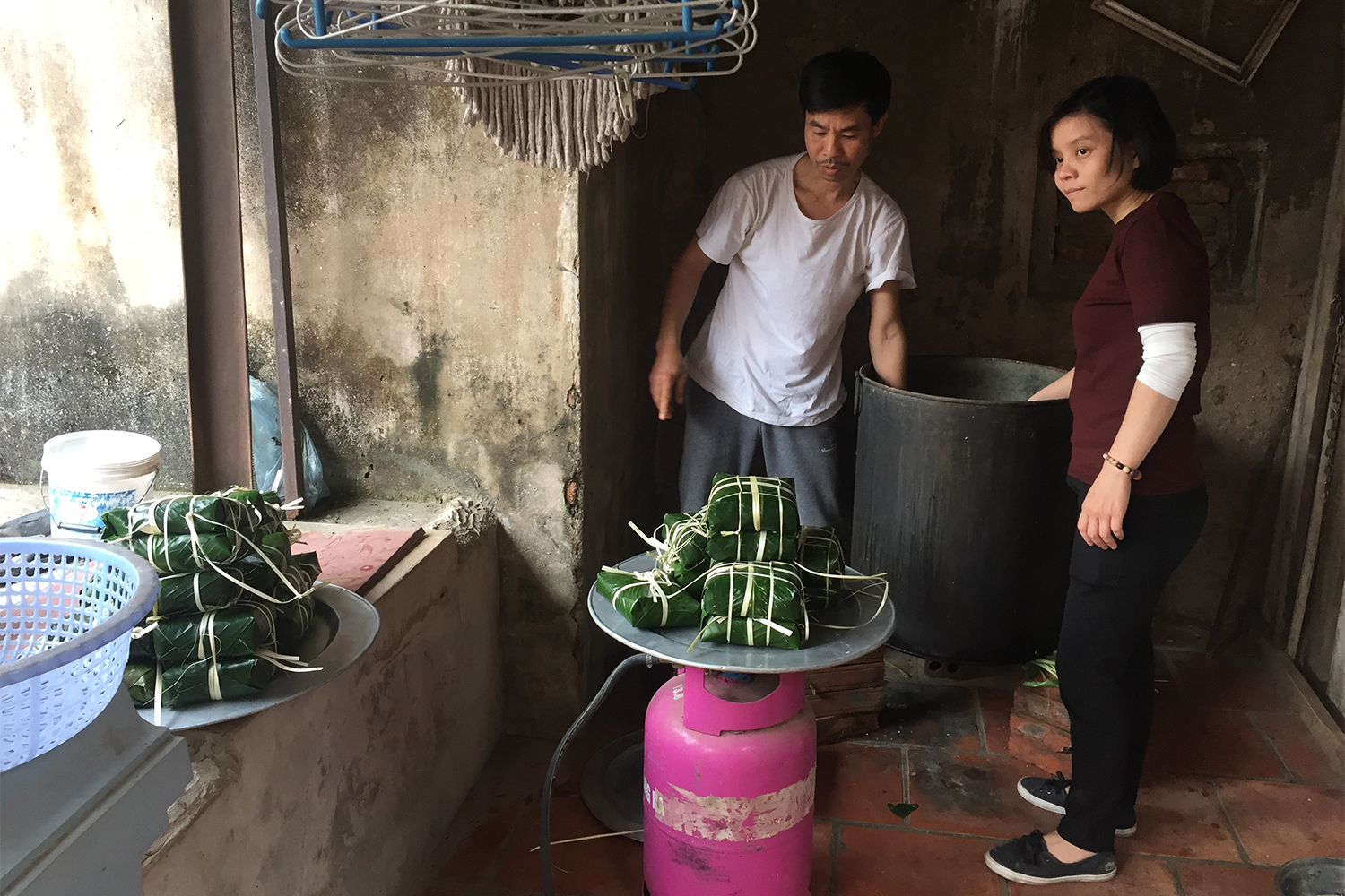 Diep et Cueng, son beau-frère, autour de la marmite dans laquelle ont été déposés les banh chungs. Ce gâteau typique du Têt doit cuire 10h !