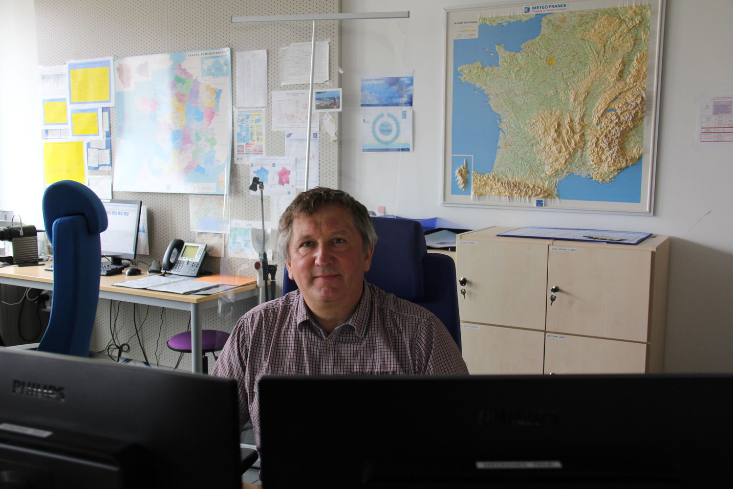 Devant Jean-Yves CHOPLIN, trois ordinateurs qui affichent les cartes météo avec différents paramètres. © Globe Reporters