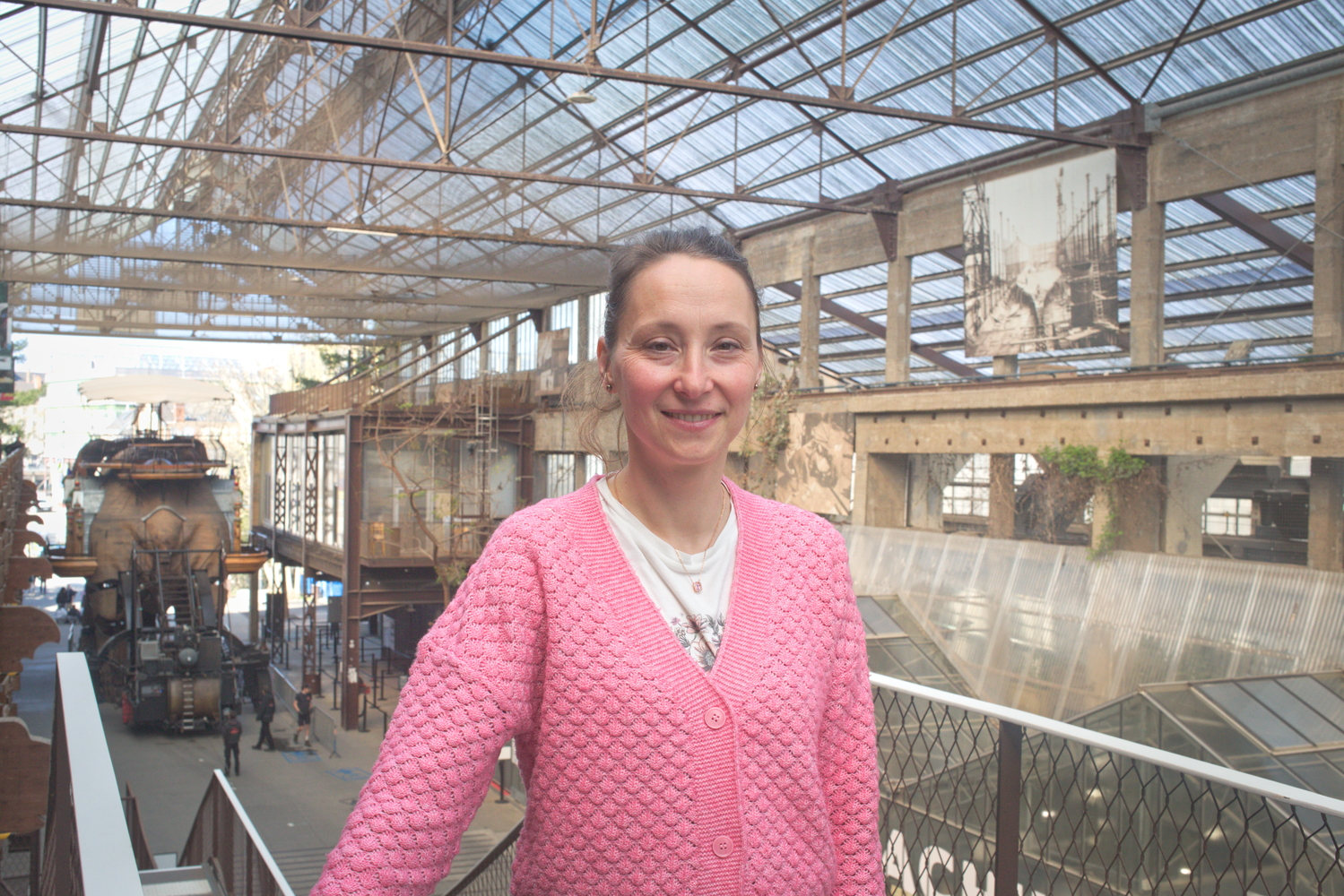 Portrait d’Ania, responsable de la production culturelle, sous les Nefs. L’éléphant géant est visible de dos © Globe Reporters