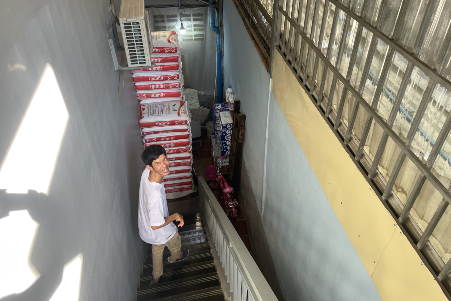 Channa vit dans un quartier où l’on compte de nombreux vendeurs de riz en gros. Son voisin stocke son riz dans le couloir de son immeuble © Globe Reporters