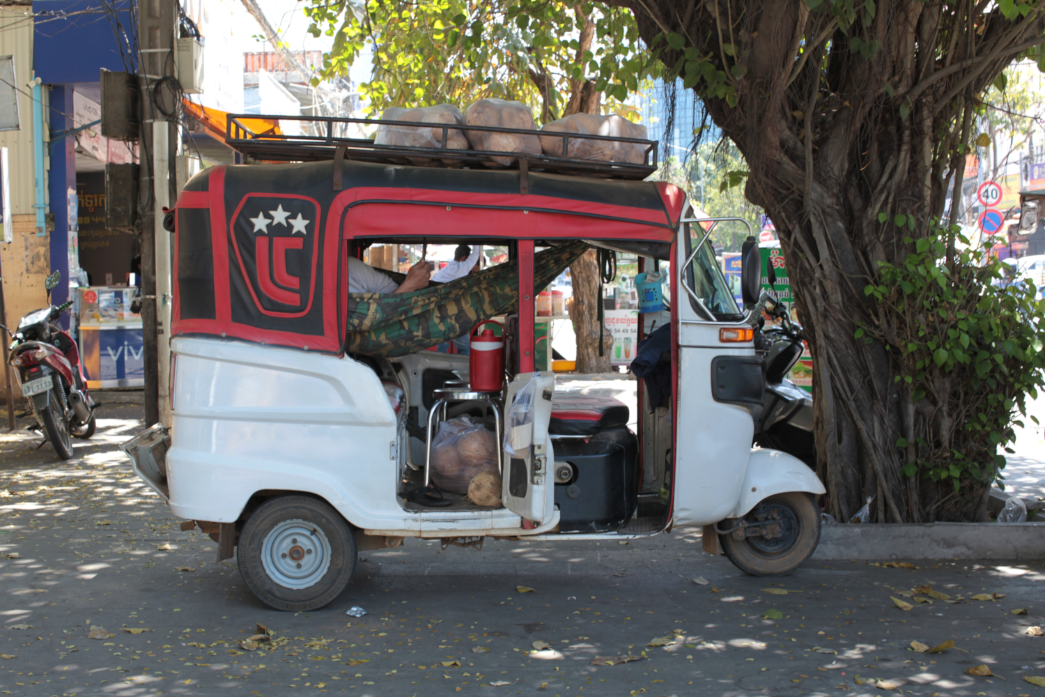 Conducteur de Tuc Tuc pendant sa pause sur un trottoir de Phnom Penh © Globe Reporters