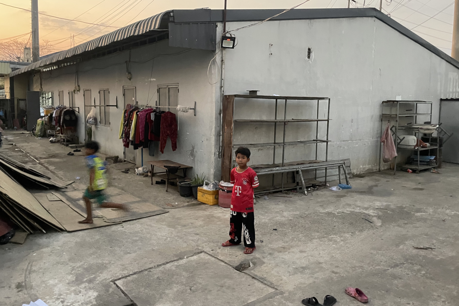 Enfant dans la ruelle d’une cité ouvrière de la banlieue de Phnom Penh © Globe Reporters