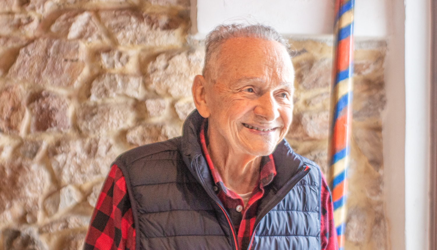 Iannis PROFIS devant le mur en pierre de sa maison, « la plus vieille de Koropi » © Globe Reporters